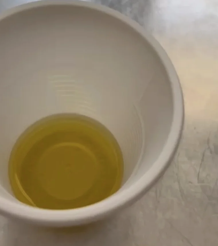 Golden oliv oil shown in a small tasting cup